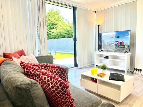 a living room with a couch and a tv at Evergreen Lodge - Two Bed Lux Flat - Parking, Garden, Patio, WIFI, Netflix - Close to Blenheim Palace & Oxford - F3 in Kidlington