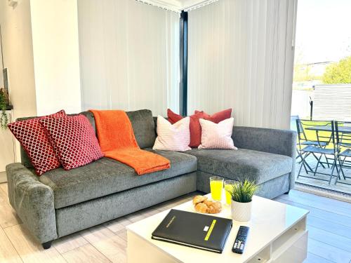 a living room with a couch with pillows on it at Evergreen Lodge - Two Bed Lux Flat - Parking, Garden, Patio, WIFI, Netflix - Close to Blenheim Palace & Oxford - F3 in Kidlington