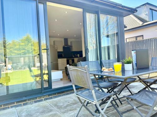a dining table and chairs on a patio at Evergreen Lodge - Two Bed Lux Flat - Parking, Garden, Patio, WIFI, Netflix - Close to Blenheim Palace & Oxford - F3 in Kidlington