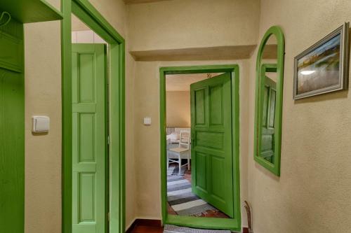 a green door in a hallway with a table at Měšťanský dům - kulturní památka Mlýnská 119 in Jindrichuv Hradec