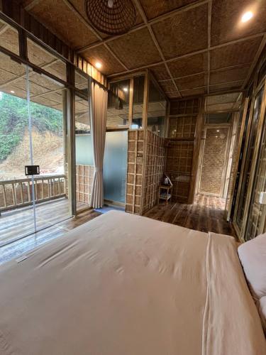 a bedroom with a large bed and a large window at Dinh Gia Trang - Homestay & Coffee in Yên Bái