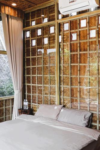 a bed in a room with a wall of wood at Dinh Gia Trang - Homestay & Coffee in Yên Bái