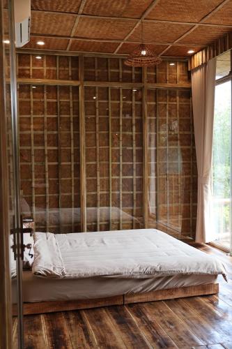 a bed in a room with a wall at Dinh Gia Trang - Homestay & Coffee in Yên Bái