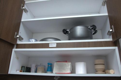 a cupboard filled with dishes and a pot at Legatus Cozy Studios 3 in Ongata Rongai 