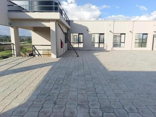 a large white building with a large patio at Legatus Cozy Studios 3 in Ongata Rongai 