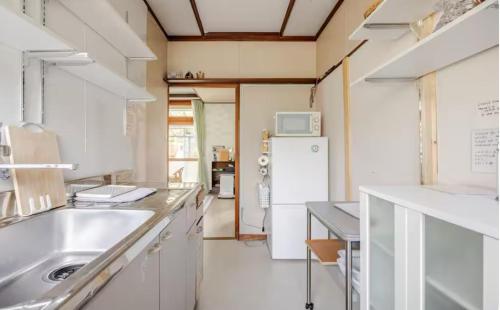 a kitchen with a sink and a refrigerator at 一軒家まるごと貸切宿Woodウッド in Shiraoi