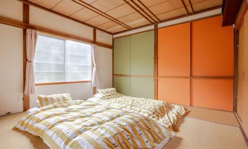 a bedroom with a bed and a large window at 一軒家まるごと貸切宿Woodウッド in Shiraoi