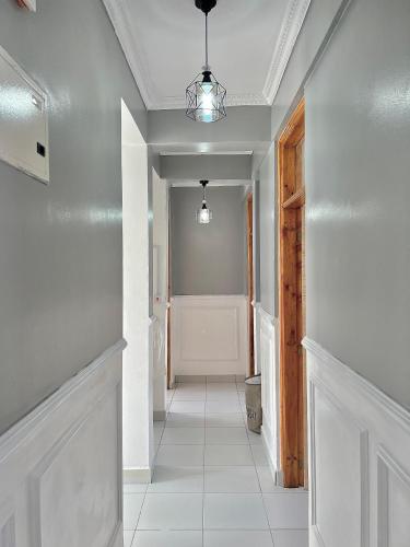a hallway with white walls and a white tile floor at Majestic Haven Suite in Mombasa