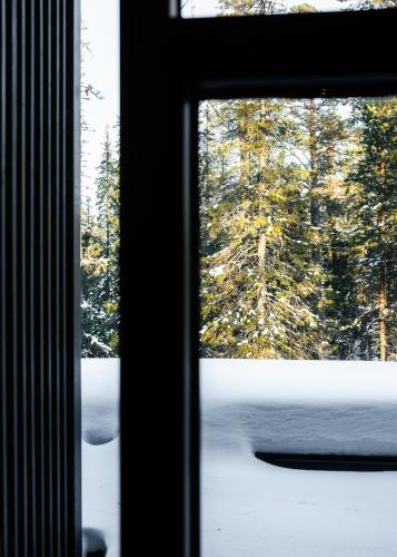 a window with a view of a snow covered forest at Luxurious Villa Rakka, Ylläs in Äkäslompolo