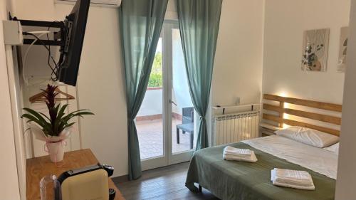a bedroom with a bed and a table and a window at Il Tiglio B&B in Borgo Montenero