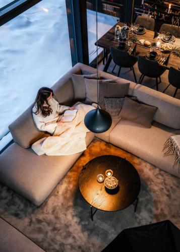 a woman laying on a couch in a living room at Luxurious Villa Rakka, Ylläs in Äkäslompolo