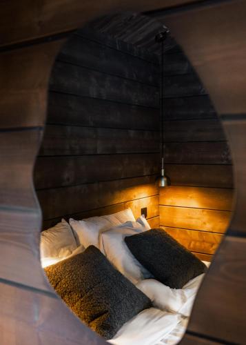 a bed with white sheets and black pillows at Luxurious Villa Rakka, Ylläs in Äkäslompolo