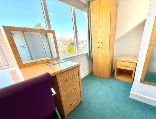a room with a desk with a mirror and a window at The Clubhouse Nairn in Nairn