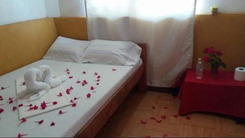 a bed with roses on it with a table at Isla Gigantes Jesa Beach Resort in Carles
