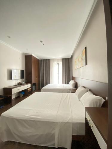 a hotel room with a large white bed in it at MOONLIGHT HOTEL in Ha Long