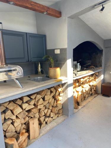 a kitchen with a counter with a pile of wood at Apartments Fishers in Vodice