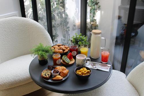 una mesa con una bandeja de comida en una silla en Maisons du Monde Hôtel & Suites - La Rochelle Vieux Port, en La Rochelle