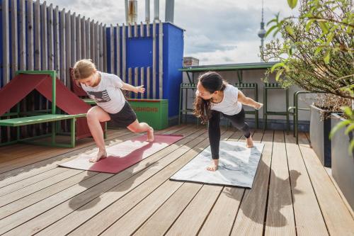two girls doing yoga on a rooftop deck at The Circus Hotel in Berlin