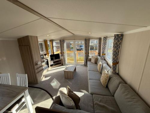 a living room with a couch and a table at Starling Lodge with Hot tub at Brickyard Lakes in Amotherby