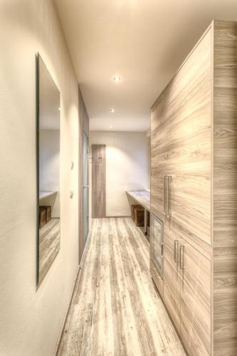 a hallway with wooden floors and a large wooden closet at City Zimmer - Appartement Dina Mariner in Lienz