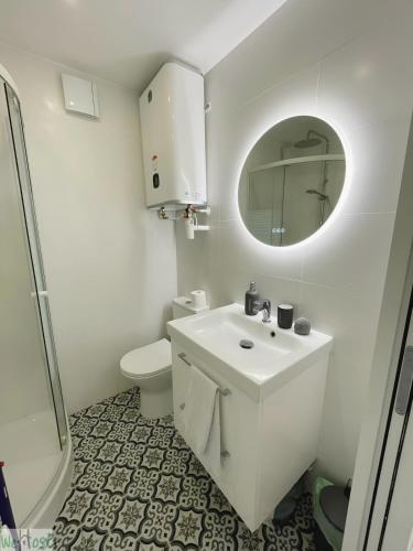 une salle de bain blanche avec un lavabo et un miroir dans l'établissement Devalois Versailles - CI - Le Devalois Paisible logement près du Château, à Le Chesnay