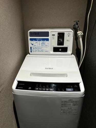 a washing machine sitting on top of a trash can at Guesthouse Hakone Lumi in Hakone