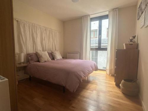a bedroom with a bed and a large window at Winahost Apartamento Temporal Esterri d'Àneu in Esterri d'Àneu