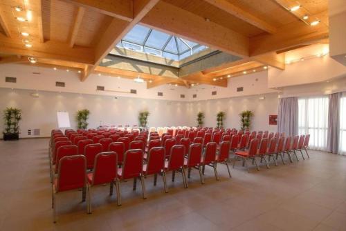 a large room with red chairs in a building at JOIVY Together Florence Urban Resort in Florence