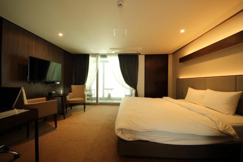 a hotel room with a bed and a desk and a television at Pyeongchang Space hubt Hotel & Resort in Pyeongchang 
