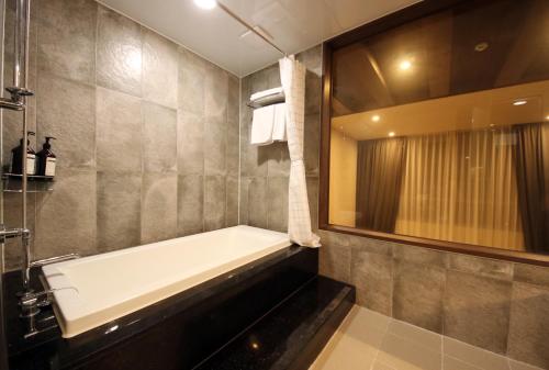 a bathroom with a bath tub and a mirror at Pyeongchang Space hubt Hotel & Resort in Pyeongchang 