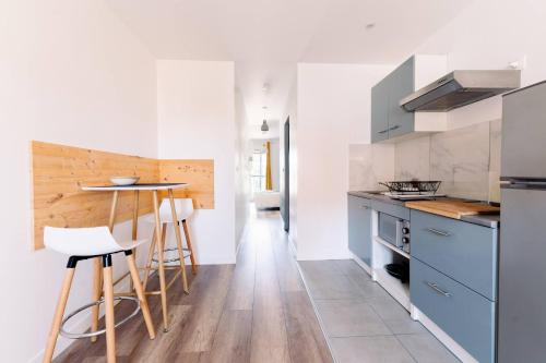 une cuisine avec des armoires bleues et une table dans l'établissement Le Van Gogh, à Valence