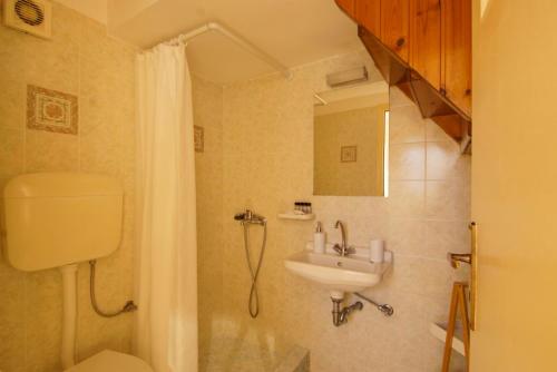 ein Badezimmer mit Toilette, Waschbecken und Dusche in der Unterkunft Kostia Studios in Skyros