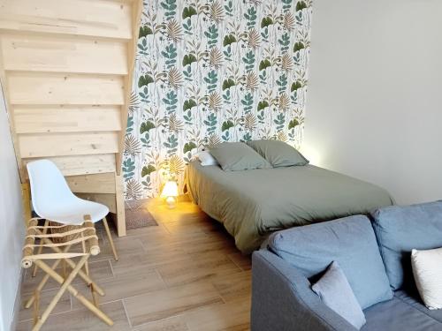 a small bedroom with a bed and a couch at La Grange du Tremblay in Channay-sur-Lathan