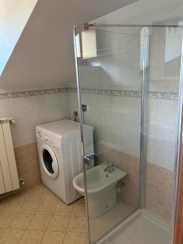 a bathroom with a washing machine and a toilet at Eden Apartment di Manenti Andrea in Oltre il Colle