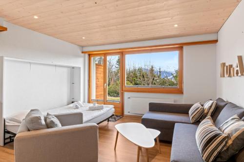 ein Wohnzimmer mit Sofa und Tisch in der Unterkunft Appartement avec terrasse, proche du centre in Crans-Montana