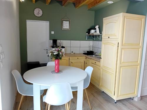 - une cuisine avec une table blanche et des chaises blanches dans l'établissement La Grange du Tremblay, à Channay-sur-Lathan