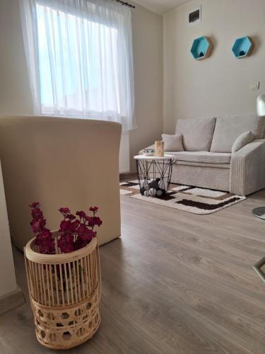 a living room with a couch and a vase of flowers at Kökénykuckó in Szeged