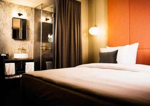 a hotel room with a bed and a mirror at Design-Hotel JAMS in Munich