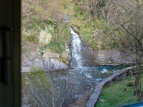 una cascada al lado de una colina junto a un río en RIVER HOUSE IN THE MOUNTAINS - with Wi-Fi, en Pianosinatico
