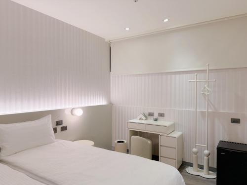 a white bedroom with a bed and a sink at 在家行旅 南西館 in Taipei