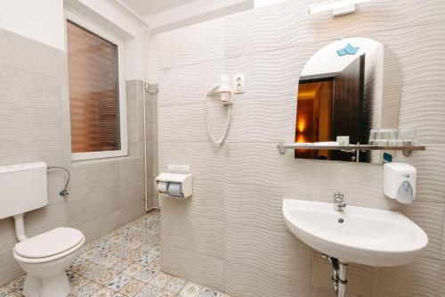 a bathroom with a sink and a toilet and a mirror at Hotel Metro in Budapest