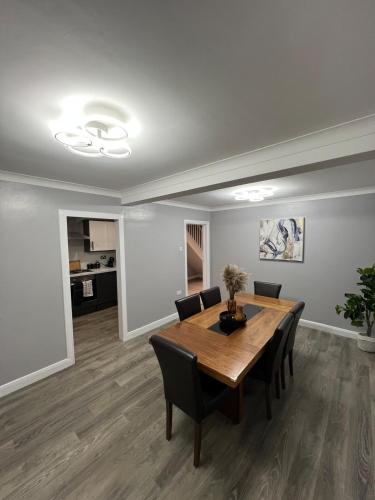 a dining room with a wooden table and chairs at Spacious 3 Bed Home - Ideal for Families & Groups in Stanford le Hope