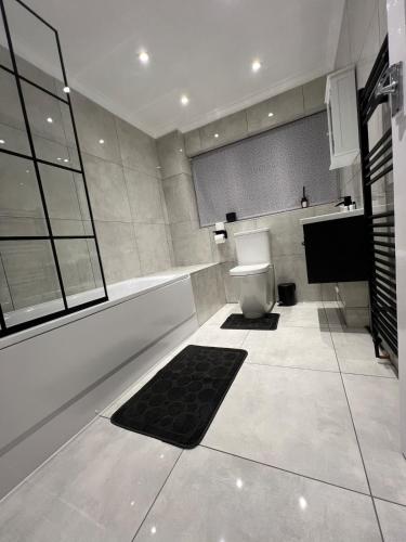 a bathroom with a toilet and a television in it at Spacious 3 Bed Home - Ideal for Families & Groups in Stanford le Hope