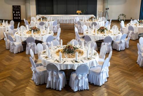 a group of tables with white chairs and tablesearcher at Hotel & Gasthaus Die Perle in Perlen