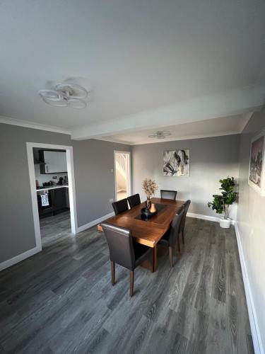 a dining room with a wooden table and chairs at Spacious 3 Bed Home - Ideal for Families & Groups in Stanford le Hope