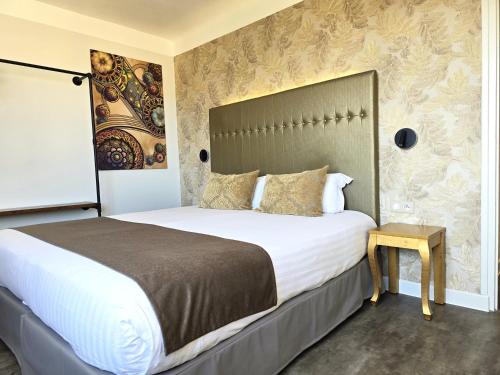 a bedroom with a large bed with a large headboard at Nyx Hôtel Indépendant Perpignan Centre Gare in Perpignan