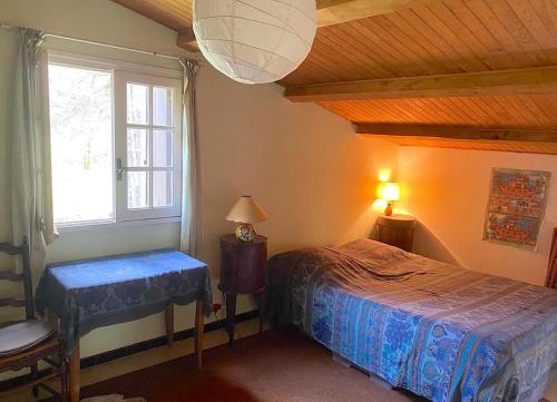 a bedroom with a bed and a window at Valfregue, grande maison familiale in Le Vigan