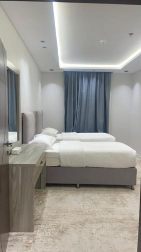 a bedroom with a large bed and a desk at قمم النماص 2 Qimam alnamas in Al Namas