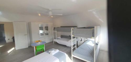 a room with two bunk beds and a table at Costabravasuites Villa Los Vientos in Calella de Palafrugell