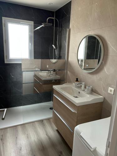 une salle de bain avec un lavabo, une douche et un miroir dans l'établissement Charmante maison, à Jard-sur-Mer